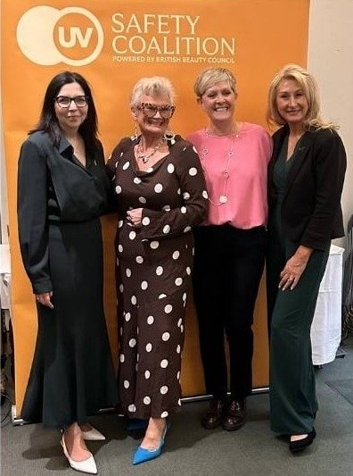 UV Safety Coalition event with four women standing in front of an orange background.