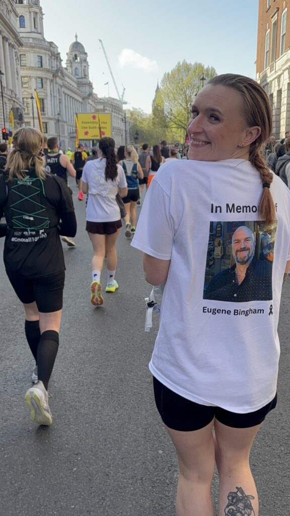 Bright woman participating in a charity run wearing a memorial T-shirt for melanoma awareness.