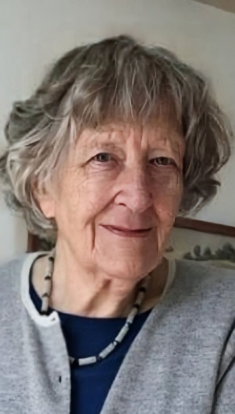 Elderly woman with grey hair smiling, promoting melanoma awareness and skin health.