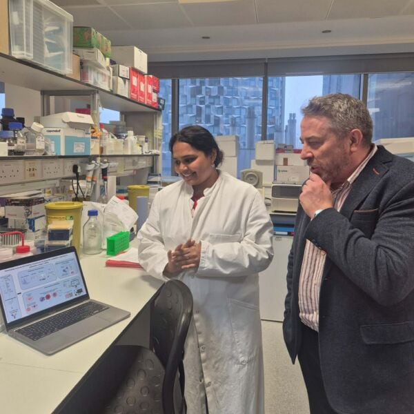 Researchers discussing melanoma research at Kings College London laboratory.